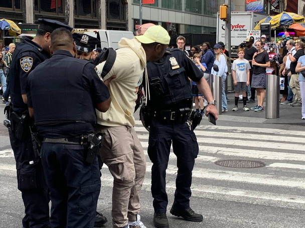 Η αστυνομία συλλαμβάνει παράνομους εμπόρους στην Τάιμ Σκουέρ. 15 Ιουνίου 2023, Νέα Υόρκη, ΗΠΑ: Η αστυνομία της Νέας Υόρκης είναι σε πλήρη ισχύ για να καθαρίσει κάθε παράνομη συμφωνία που συμβαίνει στην Times Square καθώς συλλαμβάνουν δύο υπόπτους και τους στέλνουν σε ένα κοντινό αστυνομικό τμήμα.  - Φωτογραφία, εικόνα