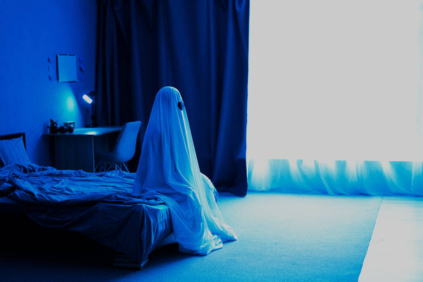 ハロウィンパーティーのコンセプト。寝室に幽霊だ。シートゴーストの衣装。トーン写真、コピースペース - 写真・画像