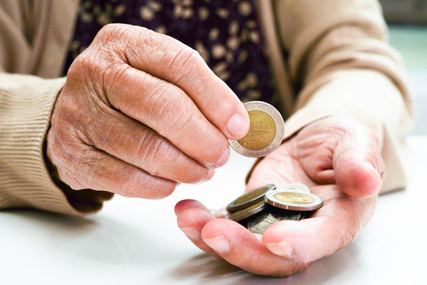 Retired elderly woman counting coins money and worry about monthly expenses and treatment fee payment. - Fotografie, Obrázek