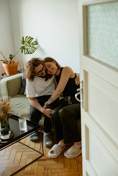 Paar umarmt und lächelt mit Liebe und Zärtlichkeit im Wohnzimmer. Gute Beziehungszeit - Foto, Bild