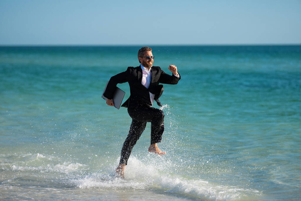 Excited businessman in wet suit run in sea. Funny business man, crazy comic business concept. Remote online working. Crazy summer business. Fun business lifestyle. Funny freelance businessman - Photo, Image