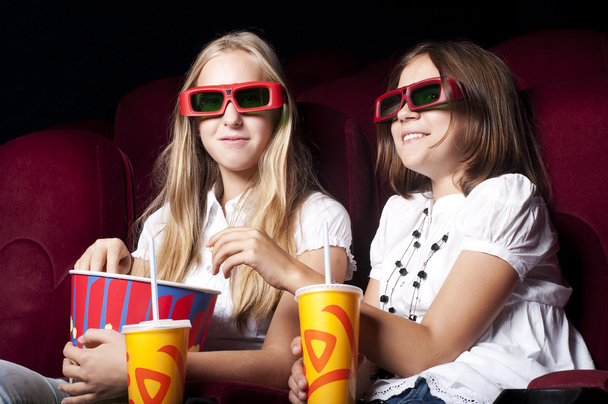 Kaksi kaunista tyttöä katsomassa elokuvaa elokuvissa.
 - Valokuva, kuva