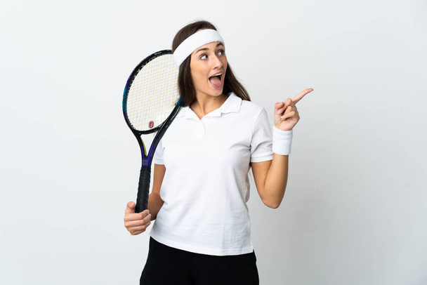 Jeune joueuse de tennis sur fond blanc isolé dans l'intention de réaliser la solution tout en levant le doigt - Photo, image