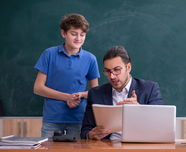 Male teacher and schoolboy in the classroom - Foto, afbeelding