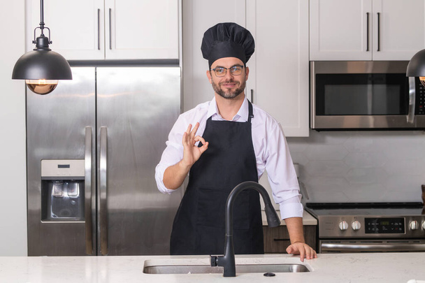 Chef cook with ok sign, delicious food. Man chef cooker baker. Millennial male chef in chefs uniform. Chef man cooking on kitchen - Valokuva, kuva