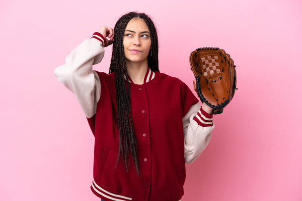 Teenager player with baseball glove isolated on pink background having doubts - Photo, Image