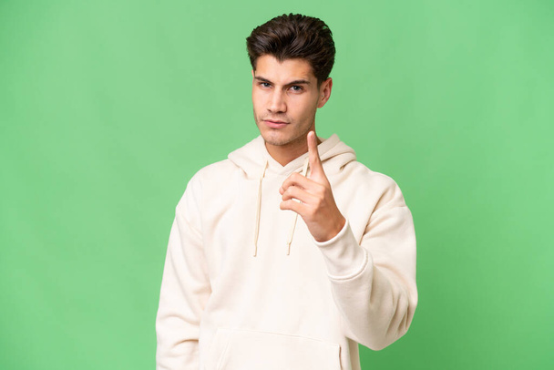 Young caucasian handsome man over isolated background frustrated and pointing to the front - Foto, Imagem