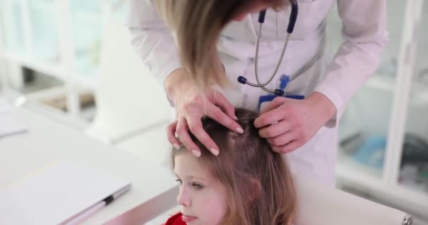 Doktor se dotkne vlasů na hlavě malé holčičky, zblízka. Tricholog, hledání vši, zpomalení - Záběry, video
