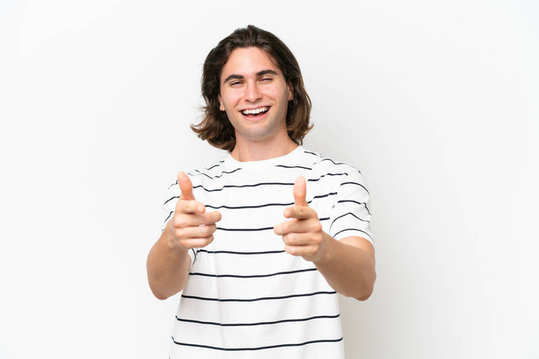 Jeune homme beau isolé sur fond blanc pointant vers l'avant et souriant - Photo, image