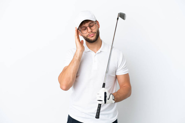 Guapo joven jugando al golf aislado sobre fondo blanco con dolor de cabeza - Foto, imagen