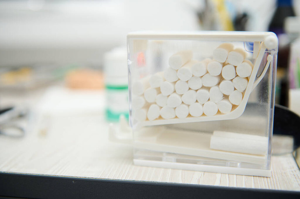Selective focus. Close-up of cotton swabs inside a transparent container in the dental clinic - Photo, Image