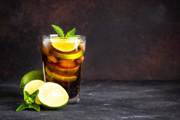 Cuba Libre alkoholischer Cocktail, Eisgetränk auf dunklem Hintergrund. - Foto, Bild