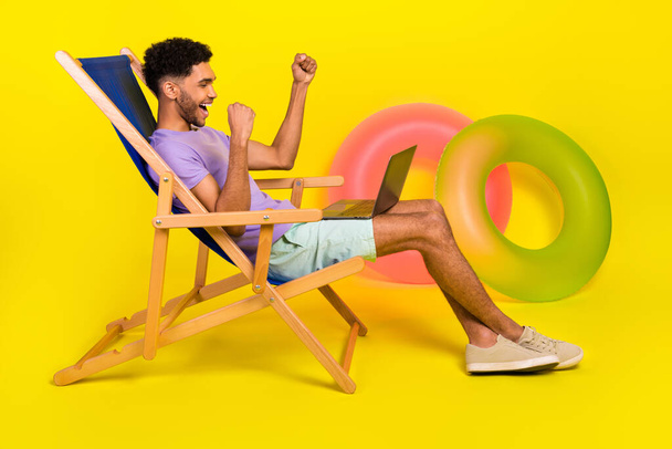 Side photo of young guy fists up hooray win lottery bet winnings high profit income celebration on vacation isolated over yellow background. - Foto, Imagen