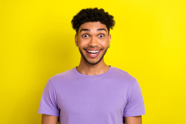 Photo of cheerful excited man wear violet t-shirt open mouth big eyes isolated yellow color background. - Photo, Image