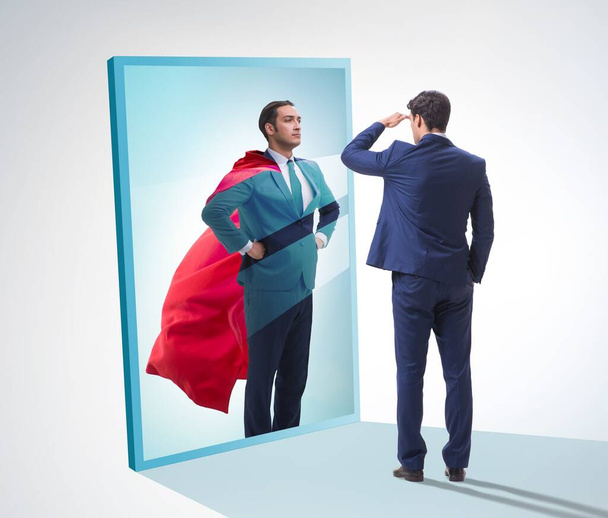 The businessman seeing himself in mirror as superhero - Photo, Image