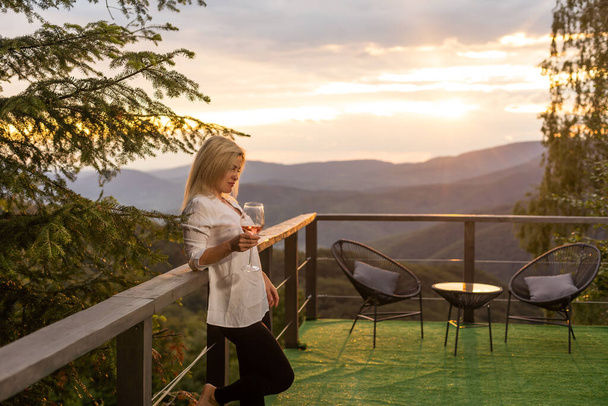 Junge Frau mit Glas Wein in friedlichen Bergen. - Foto, Bild