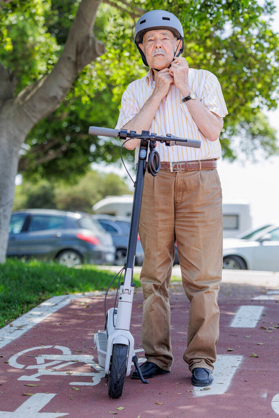 hombre mayor usando scooter eléctrico en el parque de la ciudad - Foto, Imagen