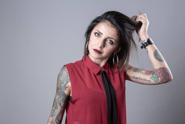 πορτρέτο της όμορφης νεαρής γυναίκας με τατουάζ σε γκρι φόντο - Φωτογραφία, εικόνα