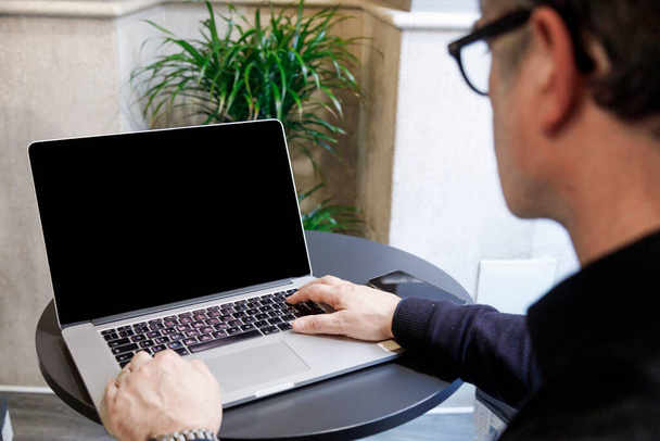 Een man met een laptop op kantoor. freelance - Foto, afbeelding