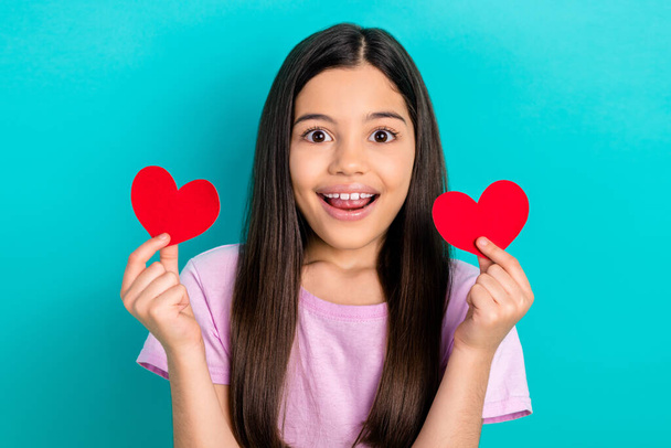 Closeup portrait of excited surprised funny girl cute preteen kid hold red paper postcards heart romance isolated on cyan color background. - Fotoğraf, Görsel