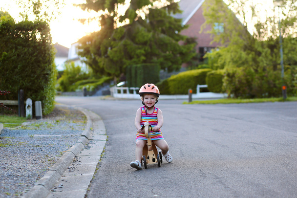Little girl riding tricycle on the street - Фото, изображение