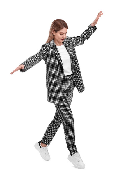 Beautiful businesswoman in suit walking on white background - Фото, изображение