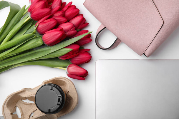 Flat lay composition with beautiful tulips and laptop on white table - Valokuva, kuva