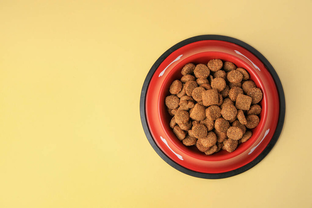 Dry dog food in feeding bowl on beige background, top view. Space for text - Fotó, kép