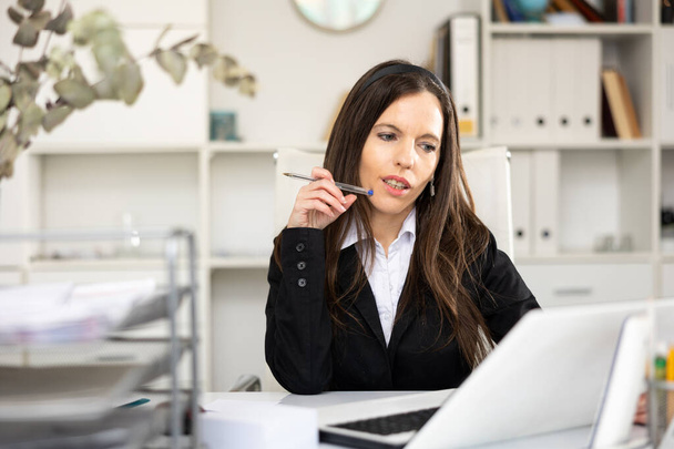 Portrait of woman accountant sitting at table in office and working. - Foto, Bild