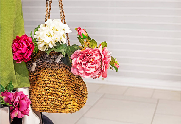 Halten Sie eine Stricktasche mit Pfingstrosen Blumen auf einem hellen Hintergrund. Die Identität der Frauen - Foto, Bild