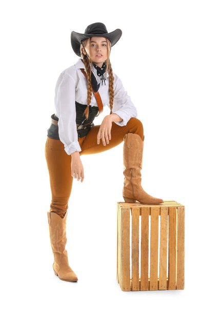 Νεαρή καουμπόισσα με ξύλινο κουτί σε λευκό φόντο - Φωτογραφία, εικόνα