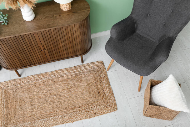 Стильный интерьер гостиной с ящиками, креслом и плетеным ковром - Фото, изображение