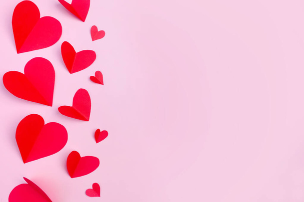 Red paper hearts on a pink background. Copy space. Postcard. The concept of Valentine's Day. - Foto, Imagem