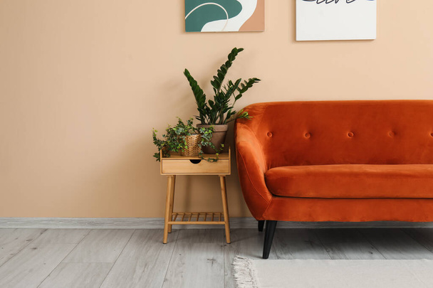 Interiér obývacího pokoje s útulnou hnědou pohovkou a pokojovými rostlinami na konci stolu - Fotografie, Obrázek