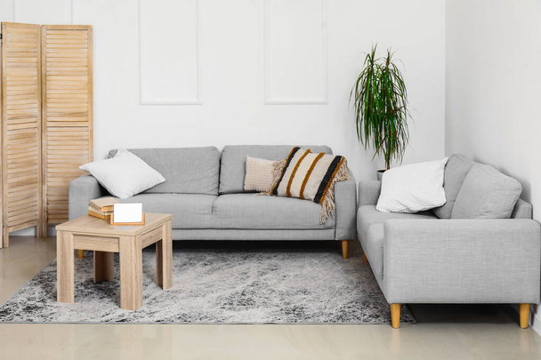 Belső tér hangulatos szürke kanapék és fa dohányzóasztal - Fotó, kép