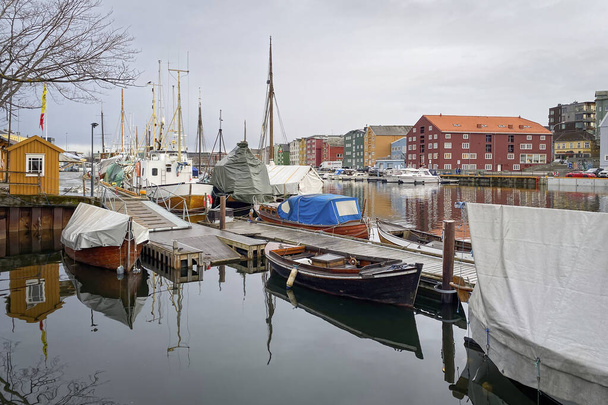Trondheim, Norway - January 13, 2020: Marina with colorful houses in the background against cloudy sky - Foto, Imagem