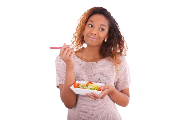 Αφρικανική αμερικανική γυναίκα τρώει σαλάτα, που απομονώνονται σε λευκό αμουδερές - Φωτογραφία, εικόνα