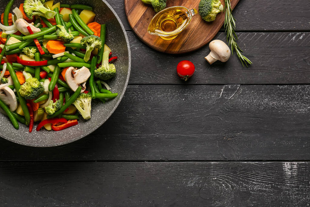 Sartén con verduras frescas sobre fondo de madera negra - Foto, Imagen