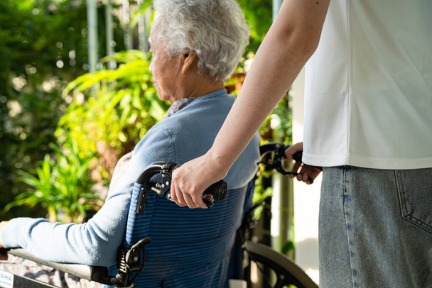 Pečovatel pomoc a péče Asijské starší žena pacient sedí na invalidním vozíku na rampu v nemocnici ošetřovatelství, zdravé silné lékařské koncepce. - Fotografie, Obrázek