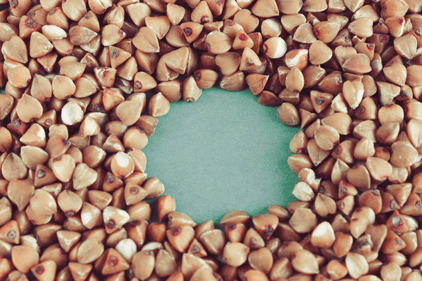 Buckwheat grains on a green background. Space for text. - Foto, Bild