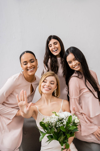 φωτογραφία γάμου, πολιτιστική ποικιλομορφία, τέσσερις γυναίκες, νύφη με τις πολυπολιτισμικές παράνυφες της κοιτάζοντας δαχτυλίδι αρραβώνων, μελαχρινή και ξανθιά, θετικότητα και χαρά, γιορτή  - Φωτογραφία, εικόνα