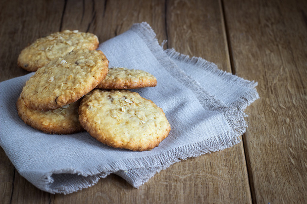oatmeal cookies on white linen napkin on wooden table. - 写真・画像