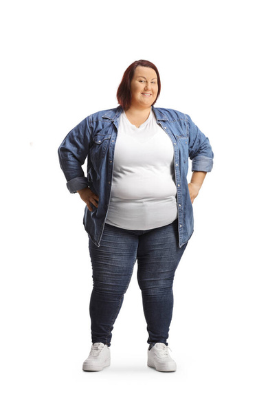 Overweight young woman in casual clothing standing and smiling isolated on white background - Фото, изображение