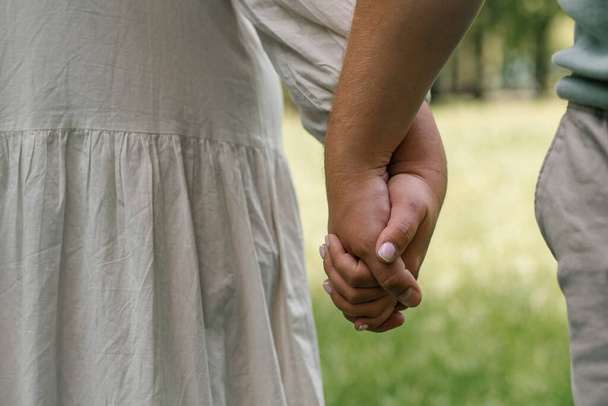 handen van paar in liefde close-up paar vasthouden handen concept ondersteuning zorg liefde gelukkig familie - Foto, afbeelding