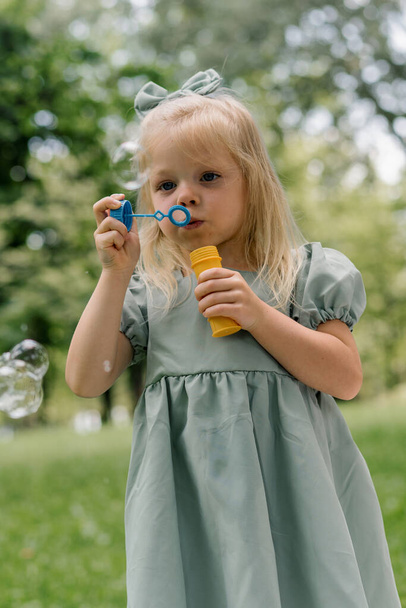 portrait Cute little girl blowing soap bubbles having fun in the park on a summer day Child playing Happy Children's Day Fun carefree childhood - Foto, afbeelding