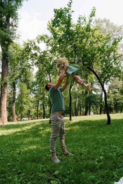 Papa joue avec un enfant dans le parc jette sa fille dans le ciel Bonne famille Fête des pères Jeu de famille avec l'enfant - Photo, image