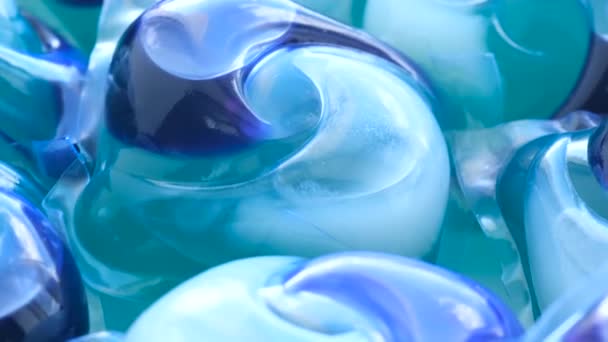Zoom-in immagine di un gruppo di cialde blu per bucato che ruotano in cerchio. Mezzi per il lavaggio di alta qualità in lavatrice. Video verticale - Filmati, video