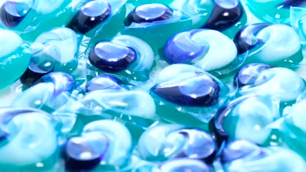 Zoom-in εικόνα μιας ομάδας από μπλε κάψουλες πλυντηρίου περιστρέφεται σε έναν κύκλο. Μέσα για υψηλής ποιότητας πλύσιμο σε πλυντήριο ρούχων. Κάθετη βίντεο - Πλάνα, βίντεο