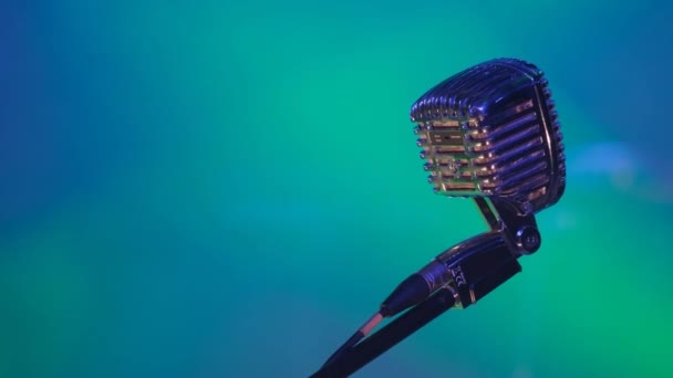 Профессиональный вокальный микрофон на микрофонной стойке освещается яркими красками. Сцена на концерте. Высококачественное 4k видео - Кадры, видео
