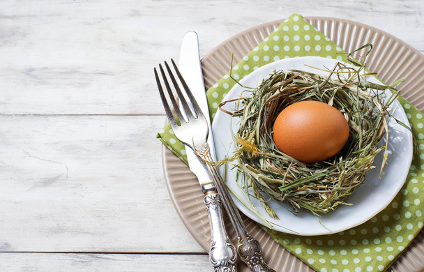 Пасхальна обстановка столу з курячими яйцями в гнізді
 - Фото, зображення